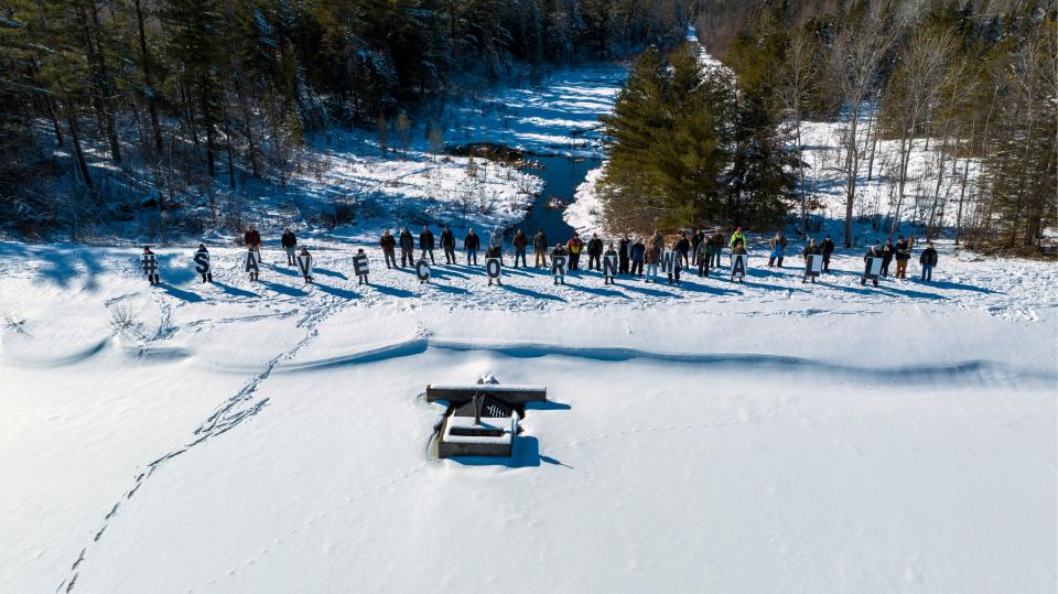 A group of citizens stand on Cornwall Flooding holding signs spelling #SaveCornwall on Saturday, Feb. 11, 2023.