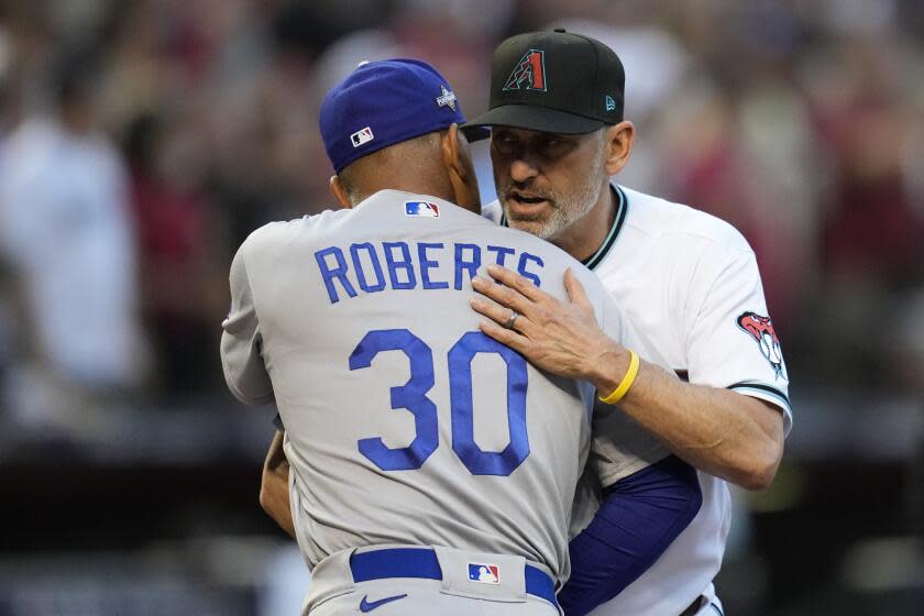 Arizona Diamondbacks manager Torey Lovullo, right, greets Los Angeles Dodgers manager Dave Roberts before Game 3 of a baseball NL Division Series, Wednesday, Oct. 11, 2023, in Phoenix. (AP Photo/Ross D. Franklin)