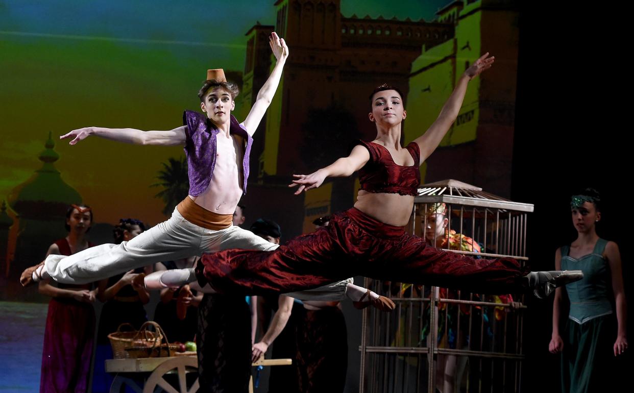 Nathan Glover as Aladdin and Emily Bellino as Jasmine leap during rehearsals for the first act of Aladdin.