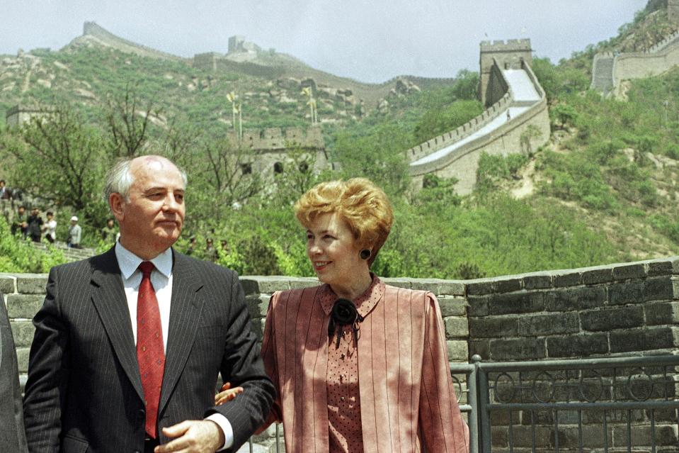 FILE - Soviet leader Mikhail Gorbachev and his wife Raisa pose for photographers during a tour of the Great Wall in Beijing, China, Wednesday, May 17, 1989. When Mikhail Gorbachev is buried Saturday at Moscow's Novodevichy Cemetery, he will once again be next to his wife, Raisa, with whom he shared the world stage in a visibly close and loving marriage that was unprecedented for a Soviet leader. Gorbachev's very public devotion to his family broke the stuffy mold of previous Soviet leaders, just as his openness to political reform did. (AP Photo/Mark Avery, File)