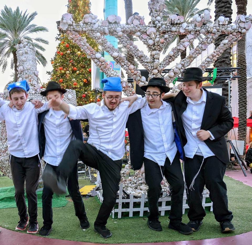 Young men dance to holiday music prior to the lighting of the menorah at Lincoln Road and Euclid Circle in Miami Beach on Thursday.