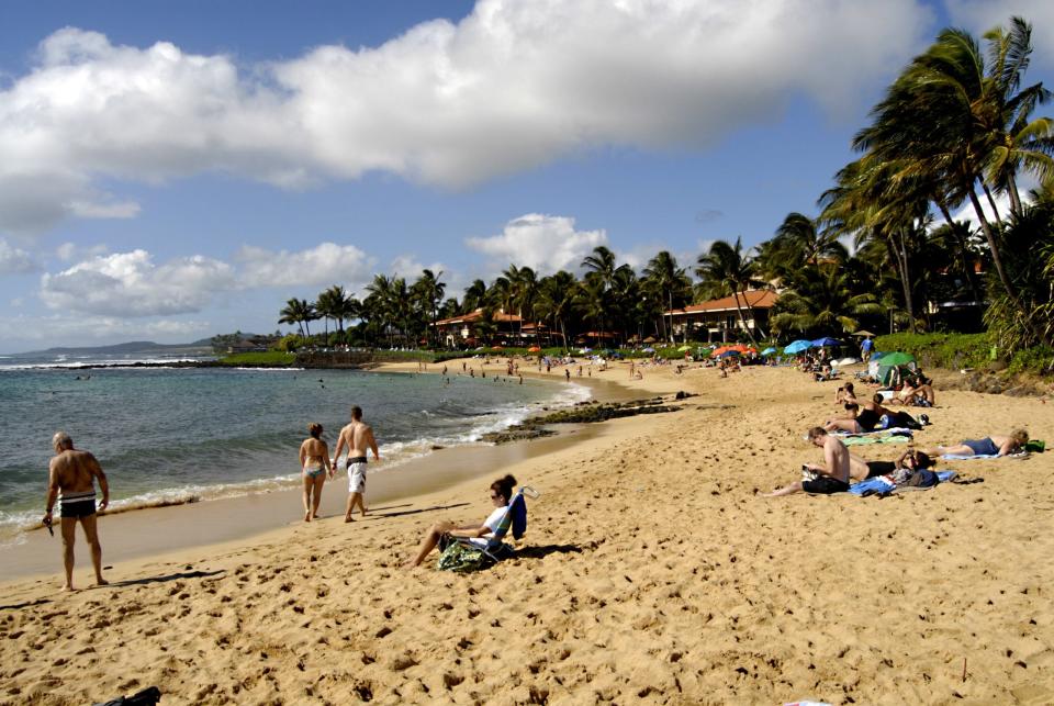 File: Vacationer swimming and sunbathing at Poipu beach Jan 2013.