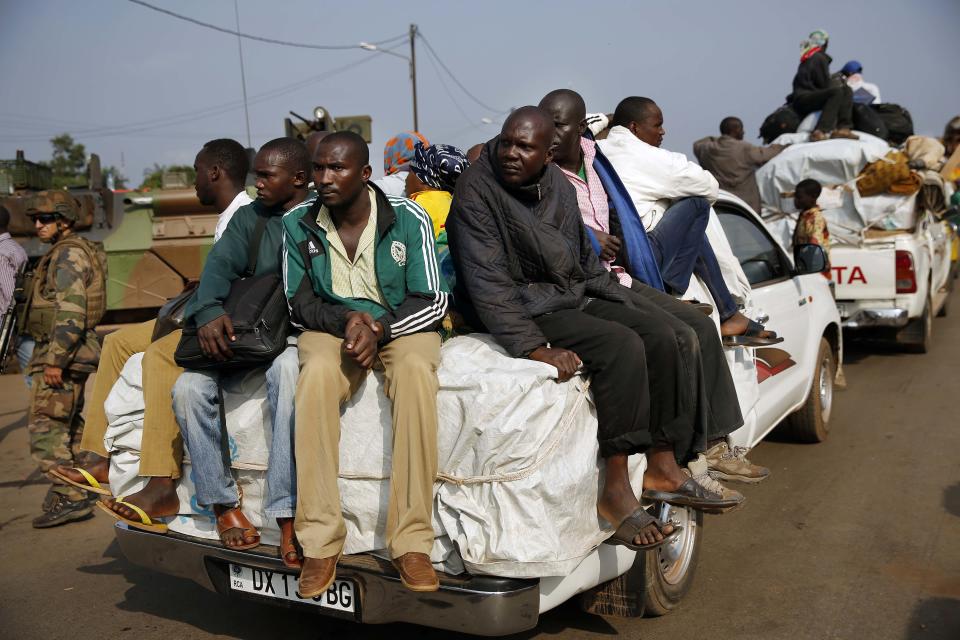 At PK12 thousands of Muslim residents from Bangui and Mbaiki flee the Central African Republic capital Bangui in a mass exodus using cars, pickups, trucks, lorries and motorcycles, escorted by Chadian troops Friday Feb. 7, 2014. Tit-for-tat violence killed more than 1,000 people in Bangui alone in a matter of days in December. An untold number have died in the weeks that followed, with most of the attacks in Bangui targeting Muslims. (AP Photo/Jerome Delay)