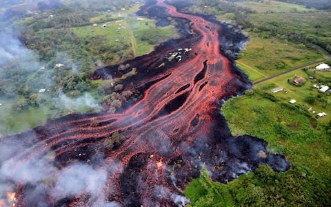  Ash plume rises from forest following a massive volcano eruption on Kilauea volcano in Hawaii - Credit: Anadolu Agency