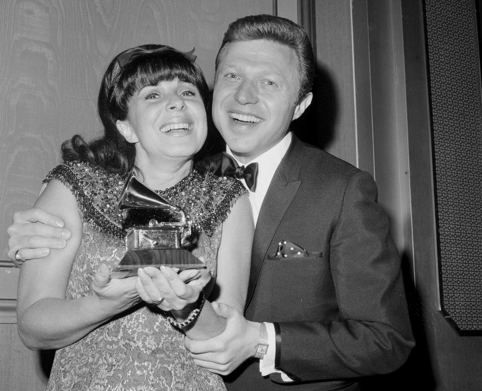 FILE - Singer Eydie Gorme, with her husband Steve Lawrence, holds the Grammy she was presented as the top female vocalist of 1966 for her recording of "If He Walked Into My Life," at the Grammy Awards in New York on March 3, 1967. Lawrence, a singer and top stage act who as a solo performer and in tandem with his Gorme kept Tin Pan Alley alive during the rock era, died Wednesday, March 6, 2024 at age 88. Gorme died on Aug. 10, 2013. (AP Photo/Marty Lederhandler, File)