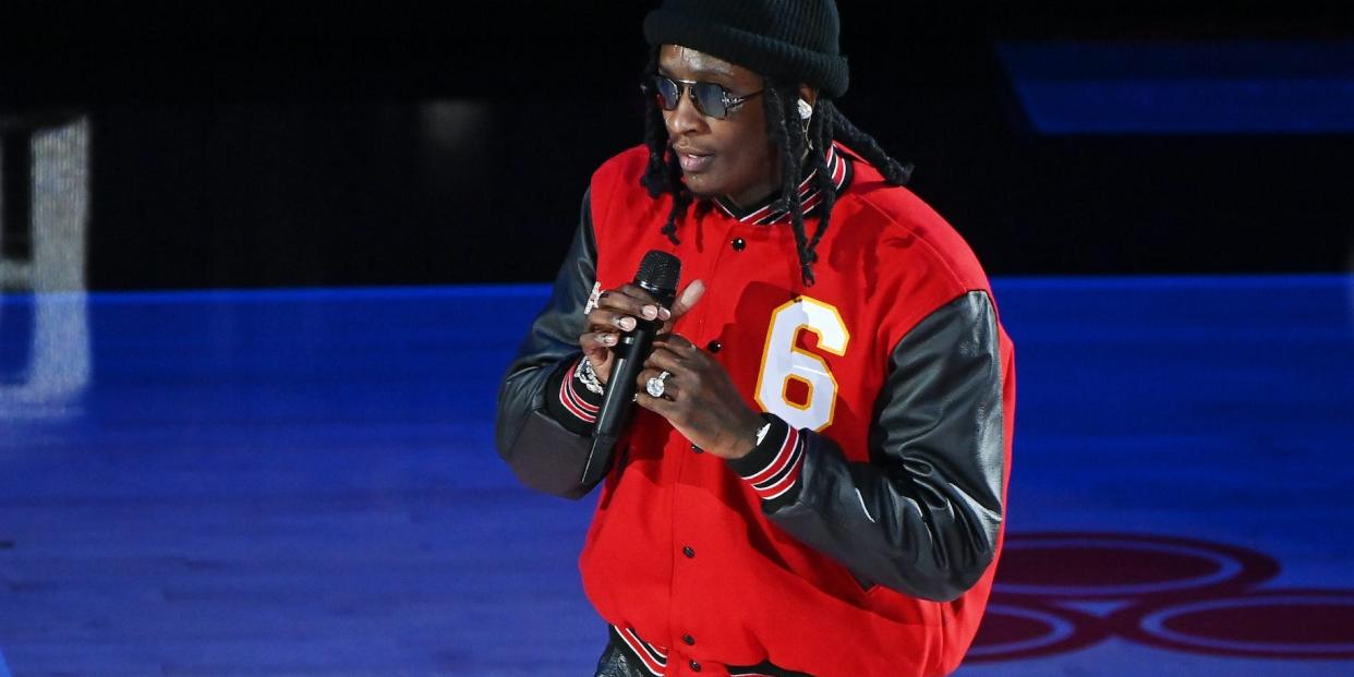 Young Thug with a microphone wearing a red jacket