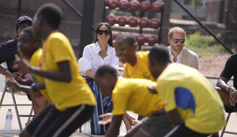 Prince Harry and Meghan, watch a performance by children during, the Giant of Africa Foundation at the Dream Big Basketball clinic in Lagos Nigeria, Sunday, May 12, 2024. Prince Harry and his wife Meghan are in Nigeria to champion the Invictus Games, which Prince Harry founded to aid the rehabilitation of wounded and sick servicemembers and veterans. (AP Photo/Sunday Alamba)