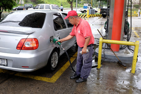 A gas station worker pumps gas into a car at a gas station of the Venezuelan state-owned oil company PDVSA in Caracas, Venezuela September 24, 2018. REUTERS/Marco Bello