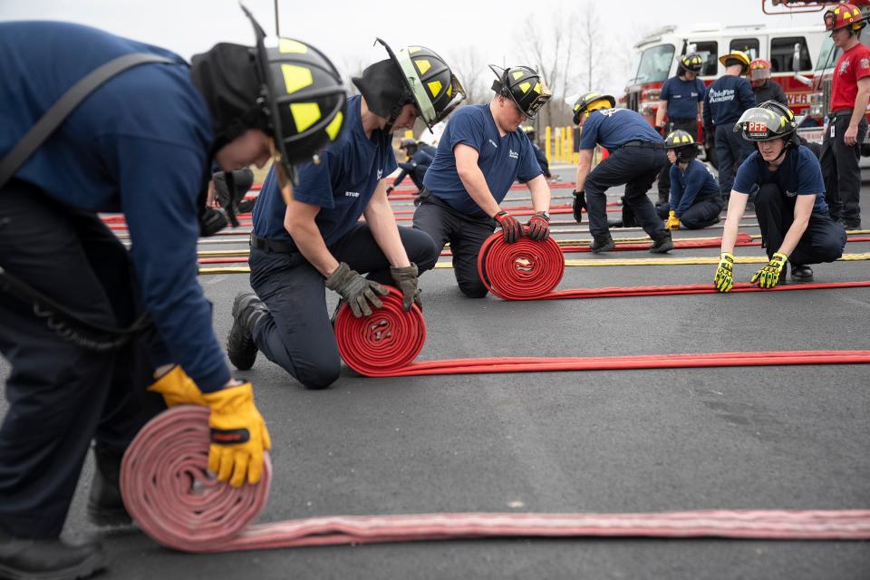 Students practice rolling a firehose after use during a training session at the Division of State Fire Marshal's Ohio Fire Academy.