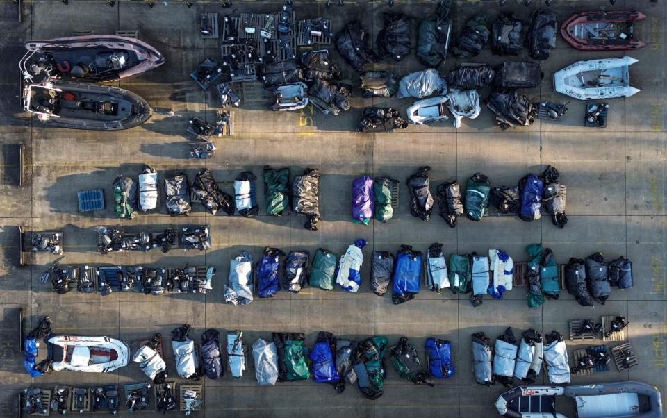Rolled-up inflatable dinghies and outboard engines used by migrants and asylum seekers who were picked up at sea whilst crossing the English Channel, stored in a Port Authority yard in Dover on Jan 16