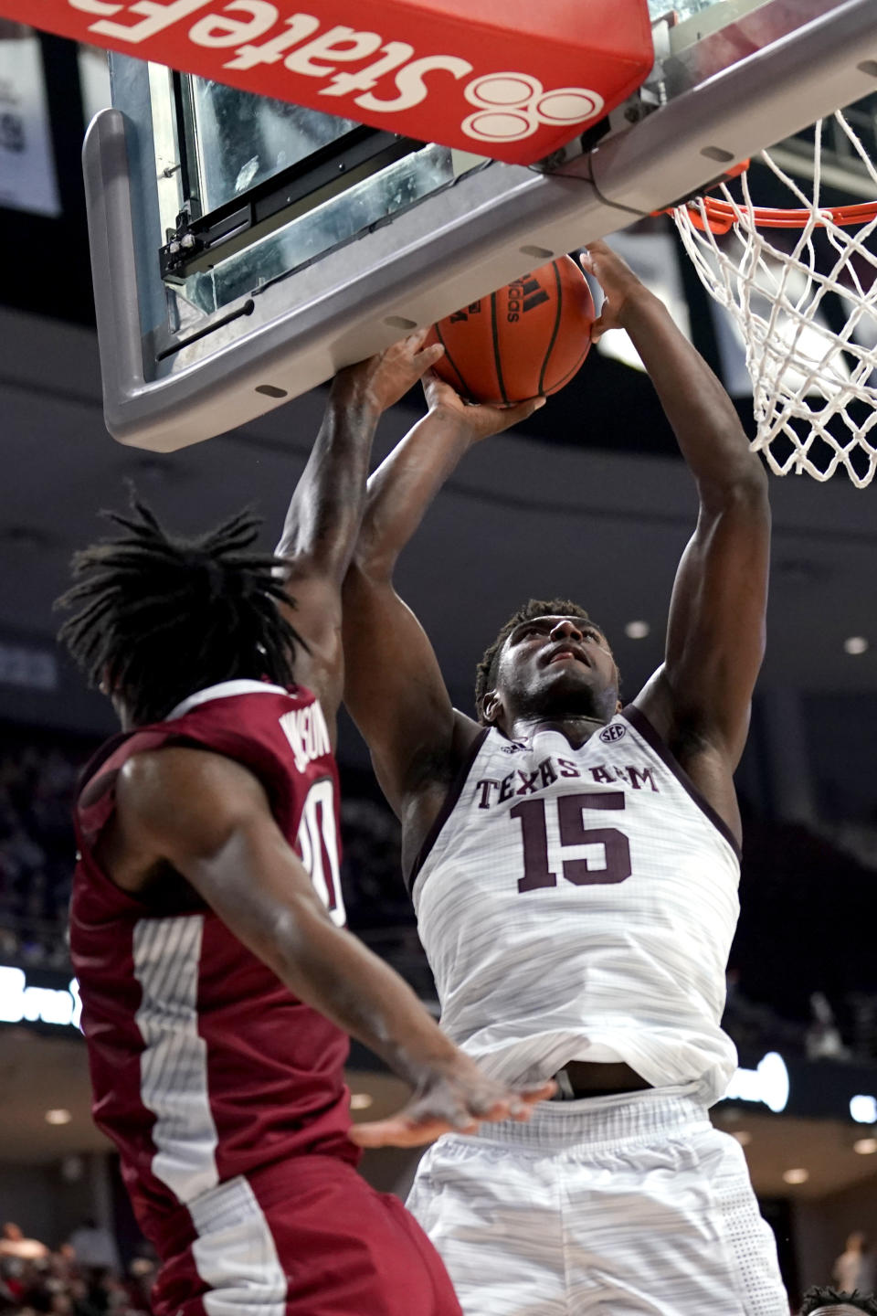 Texas A&M forward Henry Coleman III (15) makes a basket as Arkansas forward Kamani Johnson (20) defends during the second half of an NCAA college basketball game Saturday, Jan. 8, 2022, in College Station, Texas. (AP Photo/Sam Craft)