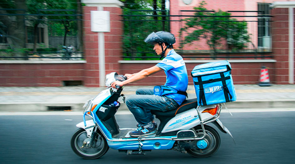 An Ele.me employee rides a motorbike while out to deliver food to a customer.