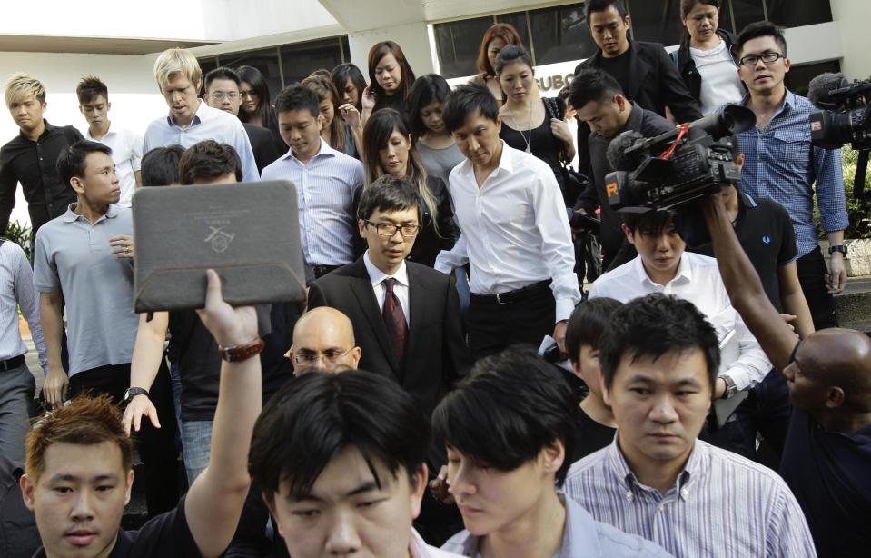 File photo of City Harvest Church founder Kong Hee and his wife surrounded by supporters as they exit the Subordinate Courts in Singapore