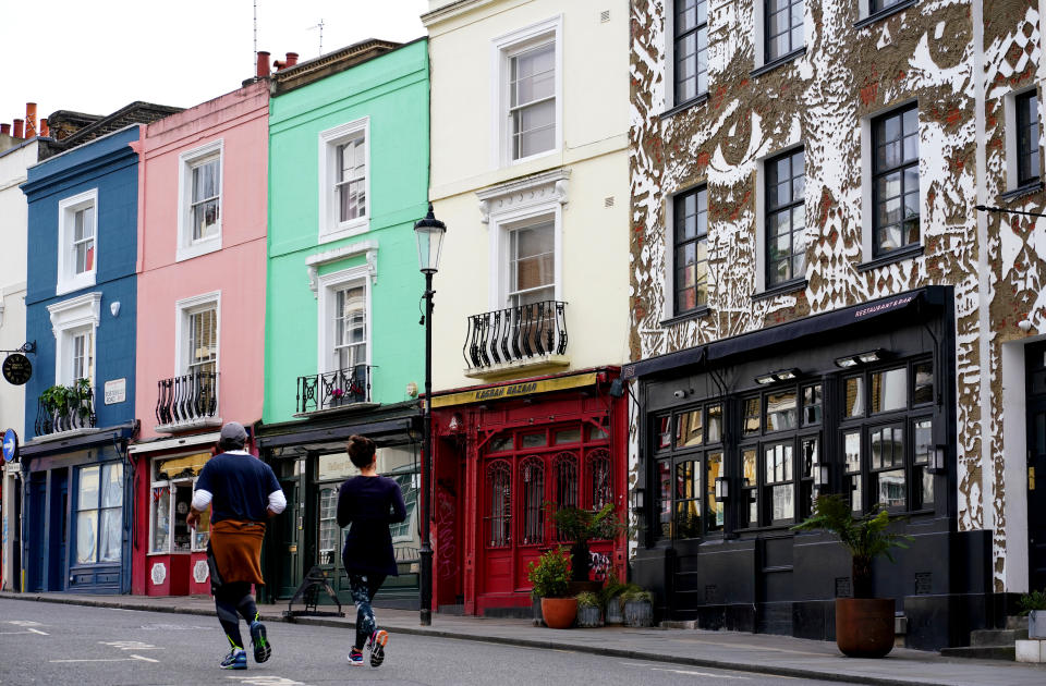 Members of the public jog down Portobello Road in Notting Hill, London as the UK continues in lockdown to help curb the spread of the coronavirus.