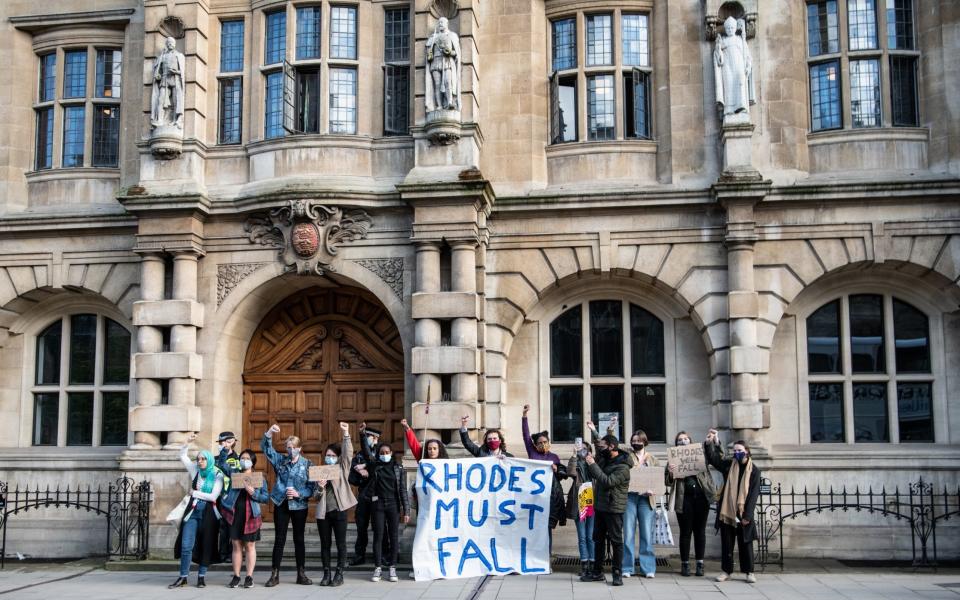 Protesters march to Oriel Colleges statue of Cecil Rhodes at the University of Oxford on May 25, 2021 in Oxford, England. - Laurel Chor 