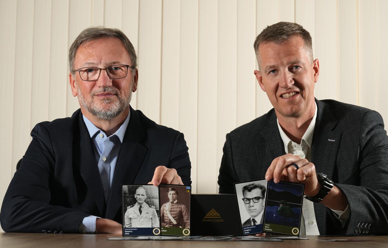 Craig Du Mez, left, and outgoing state Sen. Dale Kooyenga have launched Hero Cards, a business to honor the sacrifices of service members who lost their life while serving their country. They are shown holding cards profiling with people with ties to Wisconsin Monday, May 23, 2022 in Waukesha, Wis. A portion of their revenue is used to support to various veterans’ organizations.