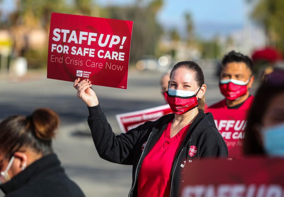 Intensive care unit registered nurse Lori Ruggiero holds a sign in protest of staffing levels as well as other patient and staff care safety concerns outside of Desert Regional Medical Center, Thursday, Jan. 13, 2022, in Palm Springs, Calif. “The United States has not experienced a ‘nursing shortage,’ only a shortage of nurses willing to risk their license or their safety for patients by working under unsafe conditions imposed on them by profit-driven employers,” Ruggiero said, reading from a prepared statement. “We’re just here to let the public know that it is happening,” she continued, referring to patient and staff deaths caused by unsafe conditions and staffing levels. 