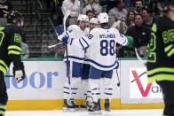 Toronto Maple Leafs center Auston Matthews, left, William Nylander (88) and Mark Giordano celebrate a goal scored by Matthews during the second period of the team's NHL hockey game against the Dallas Stars, Thursday, April 7, 2022, in Dallas. The goal was Matthews' 55th of the season. (AP Photo/Tony Gutierrez)