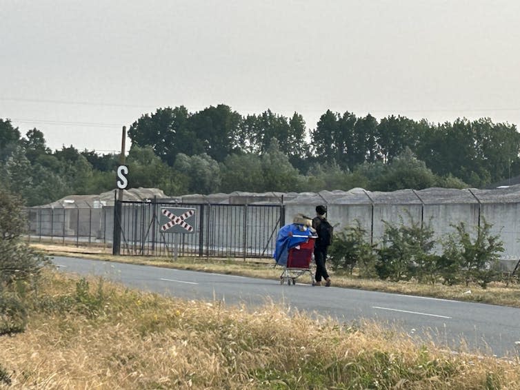 <span class="caption">A young refugee walking with all his belongings in a shopping trolley.</span> <span class="attribution"><span class="source">Sophie Watt</span></span>