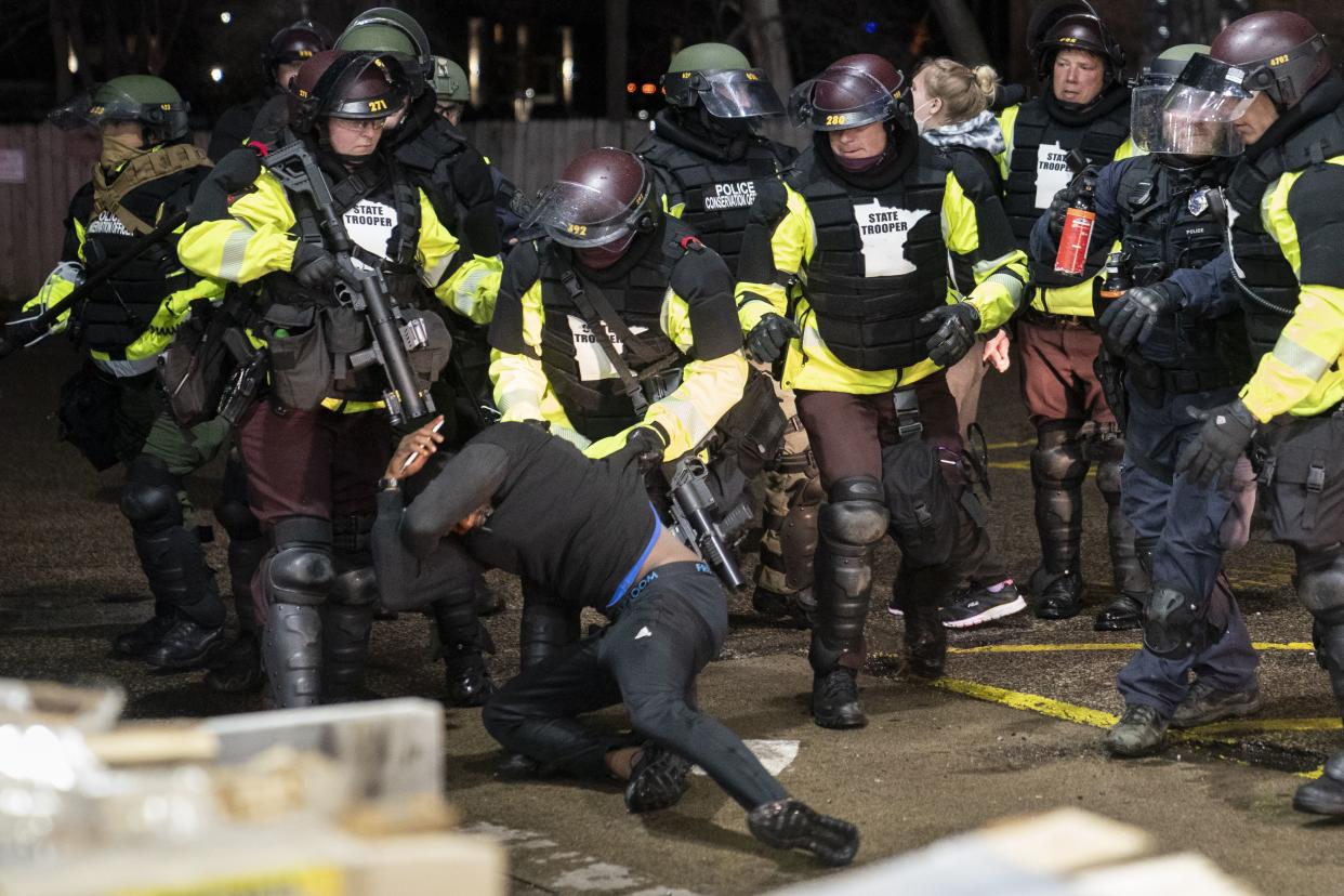 A demonstrator is arrested by police for violating curfew and an order to disperse during a protest against the police shooting of Daunte Wright, late Monday, April 12, 2021, in Brooklyn Center, Minn.