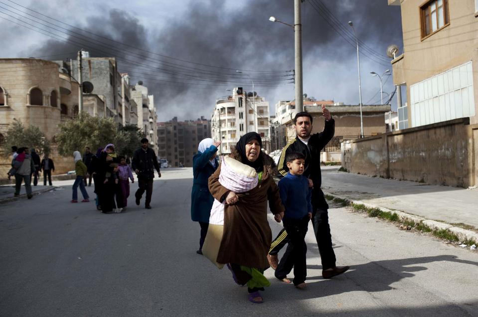 <p>A family escapes from fierce fighting between Free Syrian Army fighters and government troops in Idlib, north Syria, on March 10, 2012. This image was one in a series of 20 by AP photographers that won the 2013 Pulitzer Prize in Breaking News Photography. (Photo: Rodrigo Abd/AP) </p>