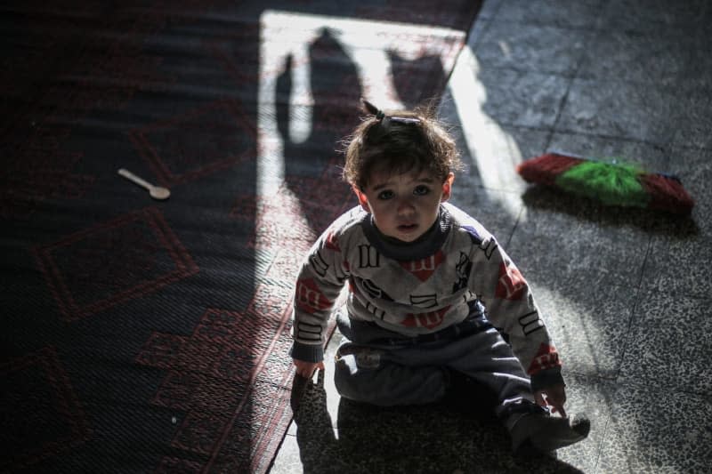 A displaced Palestinian child takes shelter inside a school run by the United Nations Relief and Works Agency for Refugees, as the war hits 100 days. Mohammed Talatene/dpa