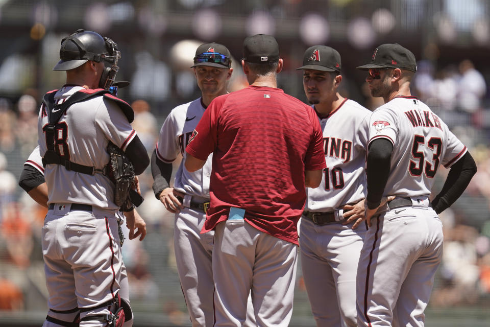 Arizona Diamondbacks manager Torey Lovullo, front center, talks with from left to right, Carson Kelly, Nick Ahmed, Josh Rojas and Christian Walker during a pitching change in the third inning of a baseball game against the San Francisco Giants, Thursday, June 17, 2021, in San Francisco. (AP Photo/Eric Risberg)