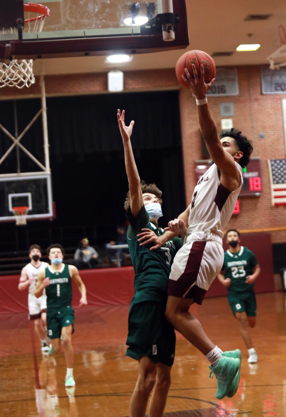 Luis Vega Jr. goes over Jake Chiquito to finish the fast break Friday in Bishop Stang's 63-49 win over Dartmouth at the John C. O'Brien Gymnasium.