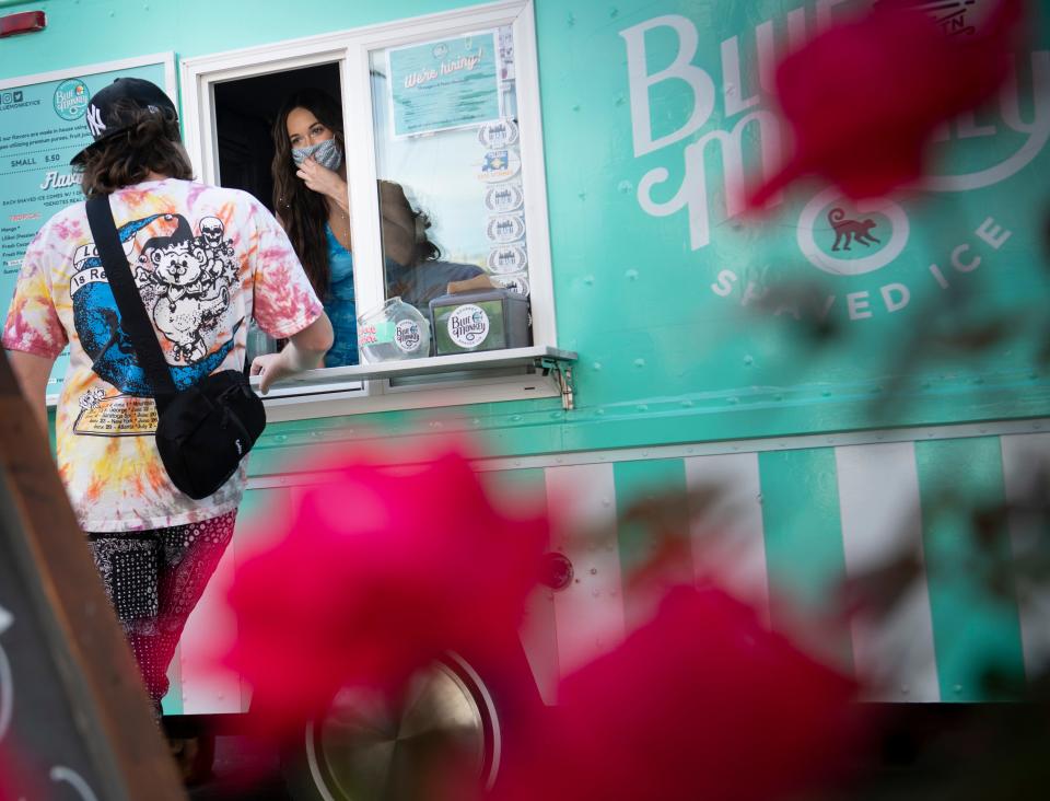 Country music artist Kacey Musgraves serves shaved ice to a fan from a Blue Monkey Shaved Ice food truck along 12th Ave. South Friday, April 30, 2021 in Nashville, Tenn. 