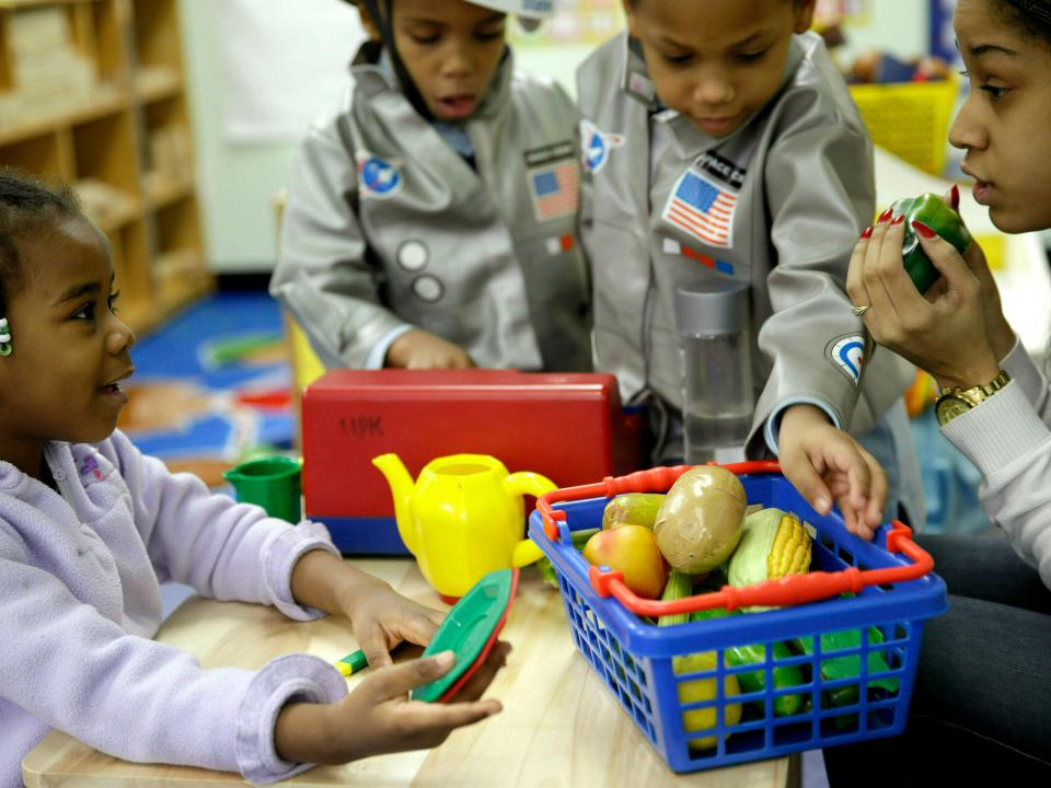 FILE - In this Tuesday, Jan. 21, 2014 file photo, Oumou Balde, 4, left, plays with her teacher Jacqualine Sanchez, right, and some pretend food in a pre-kindergarten class at the Sheltering Arms Learning Center in New York in a program that was produced in conjunction with the Sesame Street children's television show to educate children about nutrition and health. Lead author of a analysis released on Tuesday, May 21, 2019, Dr. Amanda Perak, a heart specialist at Chicago's Lurie Children's Hospital, says in most cases, kids can improve cholesterol levels by adopting healthier habits _ eating more fruits, vegetables, whole grains and less processed food, and exercising more. Researchers studied data from health surveys in 1999 through 2016 involving 26,000 U.S. kids aged 6 to 19. (AP Photo/Seth Wenig)