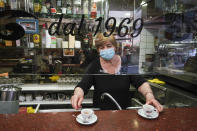 Coffee is served in the Caffe' Peru' bar, where a large plexiglass division was mounted over the counter to protect bartenders and customers from COVID-19 as they enjoy their drinks, in Rome, Wednesday, May 27, 2020. Restaurants and bars around the world are experimenting with a variety of contraptions to protect diners from the virus, to try lure back clientele while keeping them infection-free. (AP Photo/Andrew Medichini)