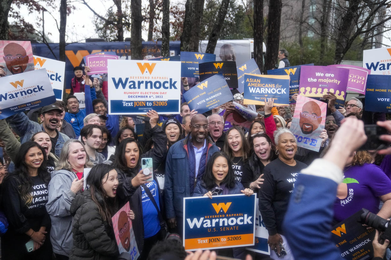 Sen. Raphael Warnock poses with supporters on election day in Norcross, Ga.  (Brynn Anderson / AP)