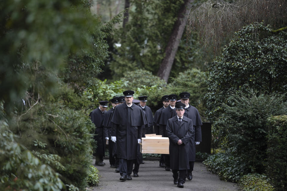 Caskets containing bones found on the grounds of the Freie Universitat, Free University are transported, for burial, at the Waldfriedhof in Berlin, Germany, Thursday, March 23, 2023. Thousands of bone fragments found in the grounds of a Berlin university where an institute for anthropology and eugenics was once located, which may include the remains of victims of Nazi crimes, were buried on Thursday. (AP Photo/Markus Schreiber)