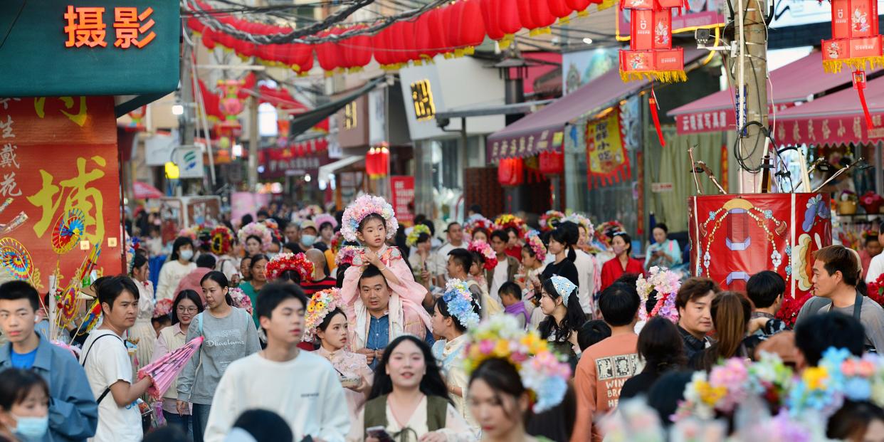 Tourists wearing flowery headwear visit Xunpu Village in Quanzhou, Fujian Province of China.