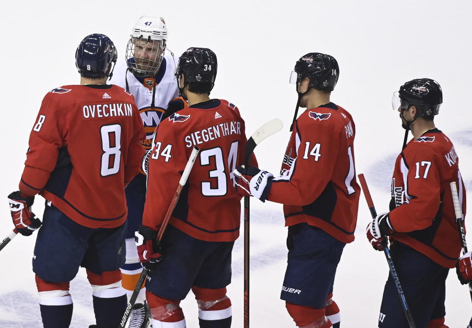 Washington Capitals left wing Alex Ovechkin (8) shakes hands with New York Islanders right wing Leo Komarov (47) after the Capitals were eliminated after an NHL Stanley Cup playoff hockey game in Toronto on Thursday, Aug. 20, 2020. (Nathan Denette/The Canadian Press via AP)