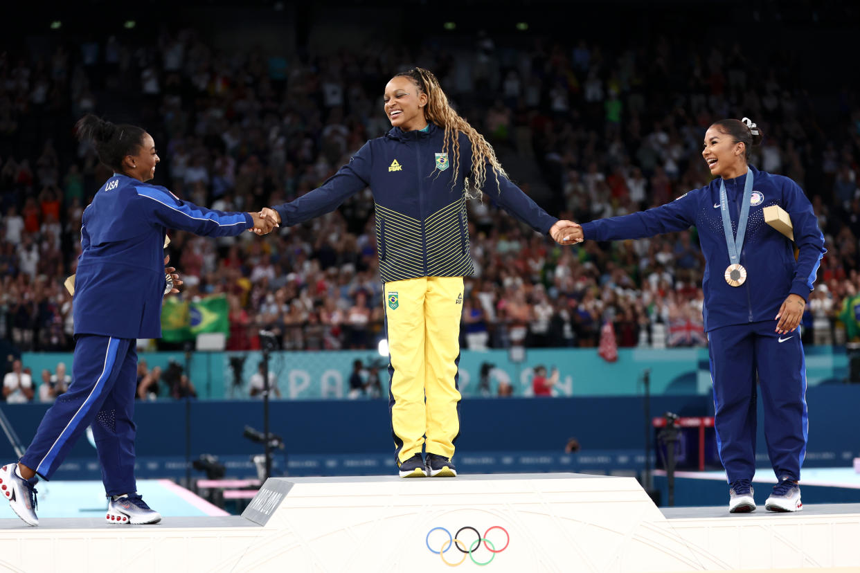 PARIS, FRANCE - AUGUST 05: Gold medalist Rebeca Andrade (C) of Team Brazil, silver medalist Simone Biles (L) of Team United States and bronze medalist Jordan Chiles (R) of Team United States celebrate on the podium at the Artistic Gymnastics Women's Floor Exercise Medal Ceremony on day ten of the Olympic Games Paris 2024 at Bercy Arena on August 05, 2024 in Paris, France. (Photo by Naomi Baker/Getty Images)