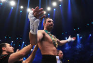 Boxer Vladimir KLitschko (L) helps his brother Ukrainian heavyweight titleholder Vitali Klitschko to put on the winner's belt after Vitali defeated Cuban challenger Odlanier Solis after their WBC heavyweight world championship boxing match in the western German city of Cologne on March 19, 2011. World heavyweight champion Vitali Klitschko won the fight and defended his WBC heavyweight title with a shock first-round knock-out of Cuban challenger Odlanier Solis. AFP PHOTO / PATRIK STOLLARZ (Photo credit should read PATRIK STOLLARZ/AFP via Getty Images)