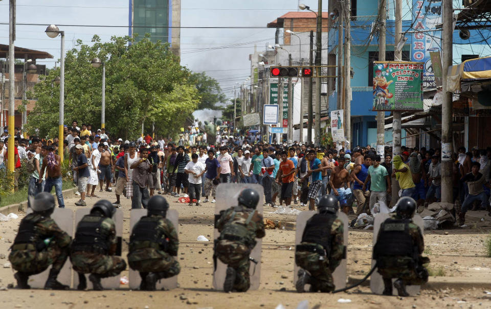 Police officers and miners clash during a protest in Puerto Maldonado, Peru, Wednesday, March 14, 2012. Thousands of illegal gold miners battled police for control of a regional capital in the Amazon basin on Wednesday and at least three people were killed by gunfire. The miners are fighting government efforts to regulate small-scale gold extraction, which is ravaging the rain forest, contaminating it with tons of mercury. (AP Photo/ Miguel Vizcarra)