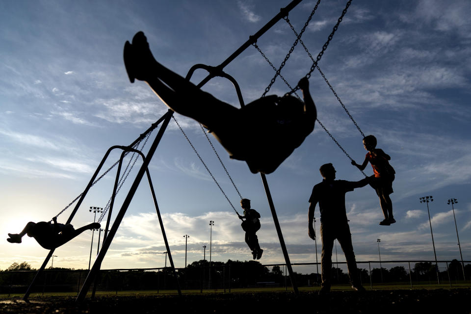 State Republican Sen. Roger Roth, pushes his four sons on a park's swing set in Appleton, Wis., Aug. 19, 2020. Republicans here say there is proof that their playbook of aiding companies with tax breaks can protect jobs and provide a foundation for growth. They point to the saving of the nearby Kimberly-Clark plant in Cold Springs through tax incentives and union concessions. "It's bigger than just 400 jobs, it's the footprint of 198 other businesses, a whole ecosystem," Roth said. (AP Photo/David Goldman)