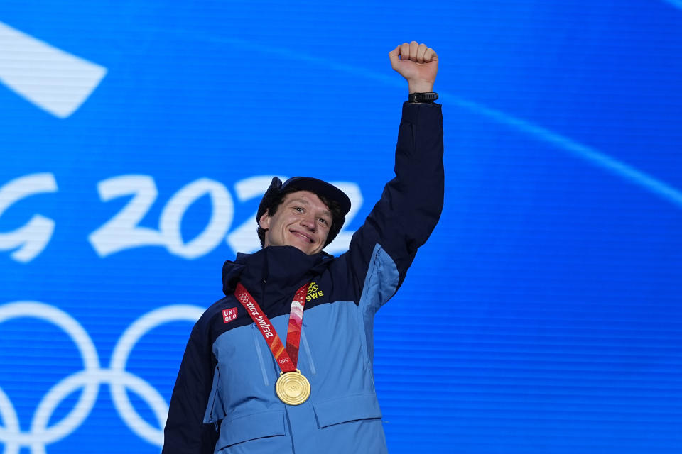 Gold medalist Nils van der Poel of Sweden celebrates on the podium during a medal ceremony for the men's speedskating 5,000-meter race at the 2022 Winter Olympics, Monday, Feb. 7, 2022, in Beijing. ((AP Photo/Jeff Roberson)