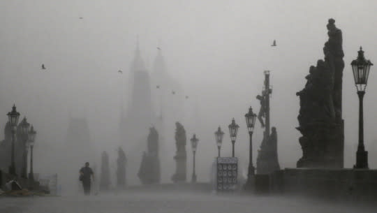 <p>A man crosses the medieval Charles Bridge during a storm in Prague, Czech Republic on May 31, 2016. Prague and other European cities were hit by a heavy thunderstorm on Tuesday. (AP Photo/Petr David Josek) </p>