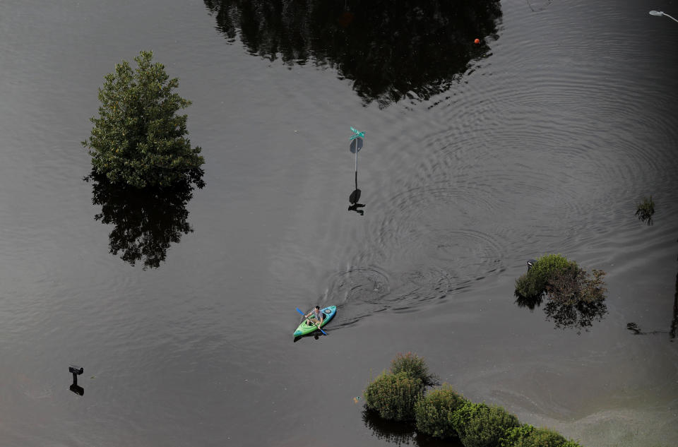 A man paddles a kayak in a flooded neighborhood in Fayetteville.&nbsp;