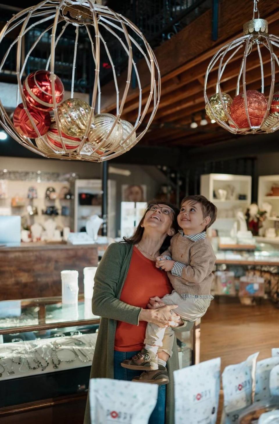 Aida Sabha with her grandson, Matisse, in her Aida’s in Old Town where he plays on the second floor. The store is closing this summer.