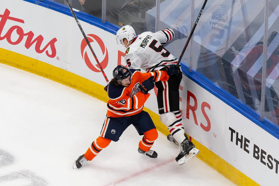 Edmonton Oilers' Kailer Yamamoto (56) hits Chicago Blackhawks' Connor Murphy (5) during the second period of an NHL hockey playoff game Monday, Aug. 3, 2020, in Edmonton, Alberta. (Codie McLachlan/The Canadian Press via AP)