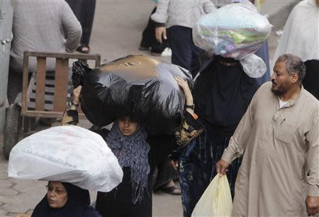 Women carry clothes bought at Al Ataba, a popular market in downtown Cairo November 11, 2013. REUTERS/Mohamed Abd El-Ghany
