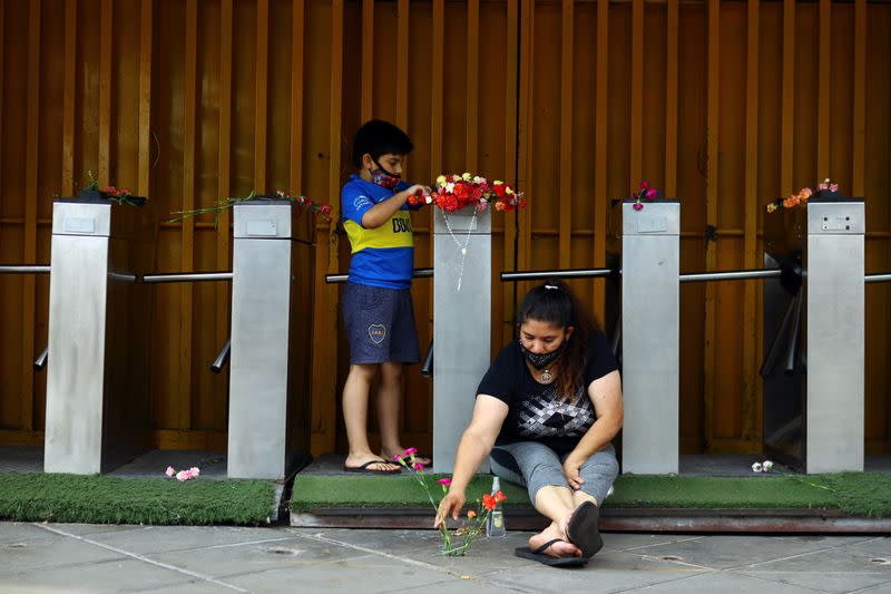 Foto del miércoles de un nuño dejando una ofrenda floral en honor a Diego Maradona en el estadio de Boca Juniors