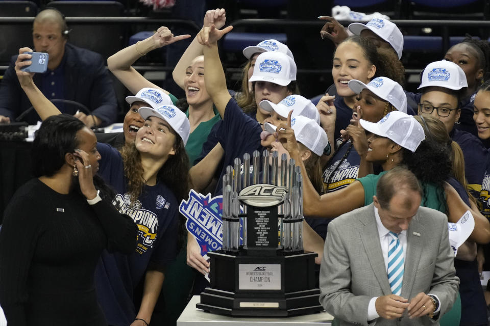 Notre Dame players take a selfie with the trophy after defeating NC State in an NCAA basketball game for the Women's Atlantic Coast Conference championship in Greensboro, N.C., Sunday, March 10, 2024. (AP Photo/Chuck Burton)