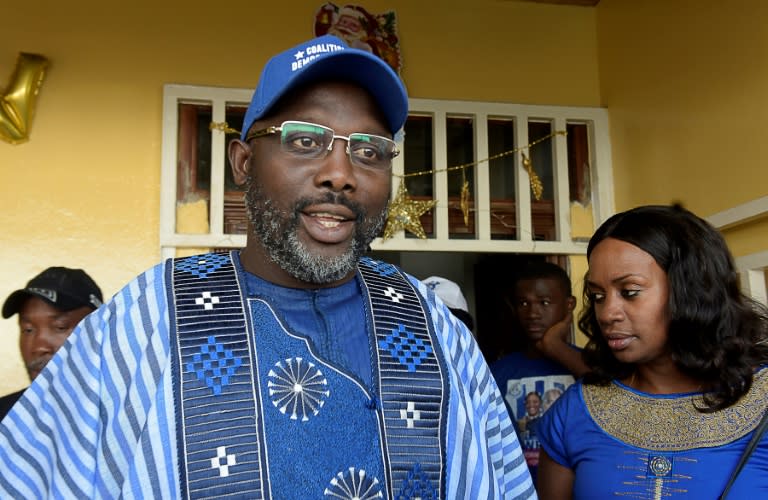 Presidential candidate and former football star George Weah, flanked by his wife Clar in Monrovia on December 23, 2017. Weah is tipped to become president on Tuesday