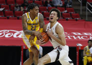 Pittsburgh's Nike Sibande (22) fouls N.C. State's Jericole Hellems (4) during the first half of an NCAA college basketball game in Raleigh, N.C., Sunday, Feb. 28, 2021. (Ethan Hyman/The News & Observer via AP)