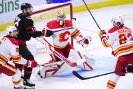 Ottawa Senators left wing Austin Watson (16) gets his stick on a flying puck as Calgary Flames goaltender David Rittich (33) keeps an eye on it during second period NHL hockey action in Ottawa on Monday, March 1, 2021. (Sean Kilpatrick/The Canadian Press via AP)